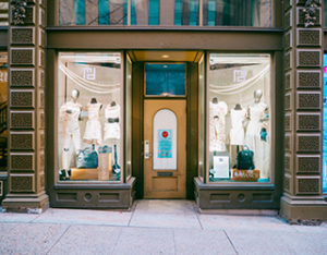 Window displays with mannequins wearing white clothing designed by Retailworks Inc.
