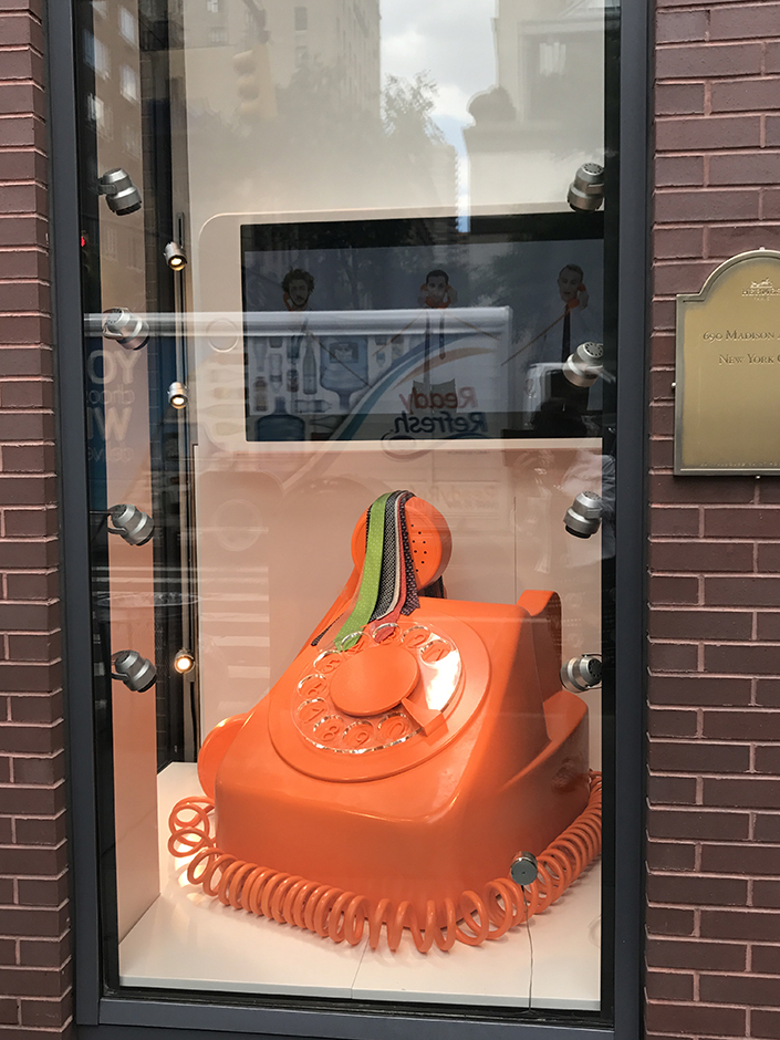 Hermes window display with oversized orange phone in New York